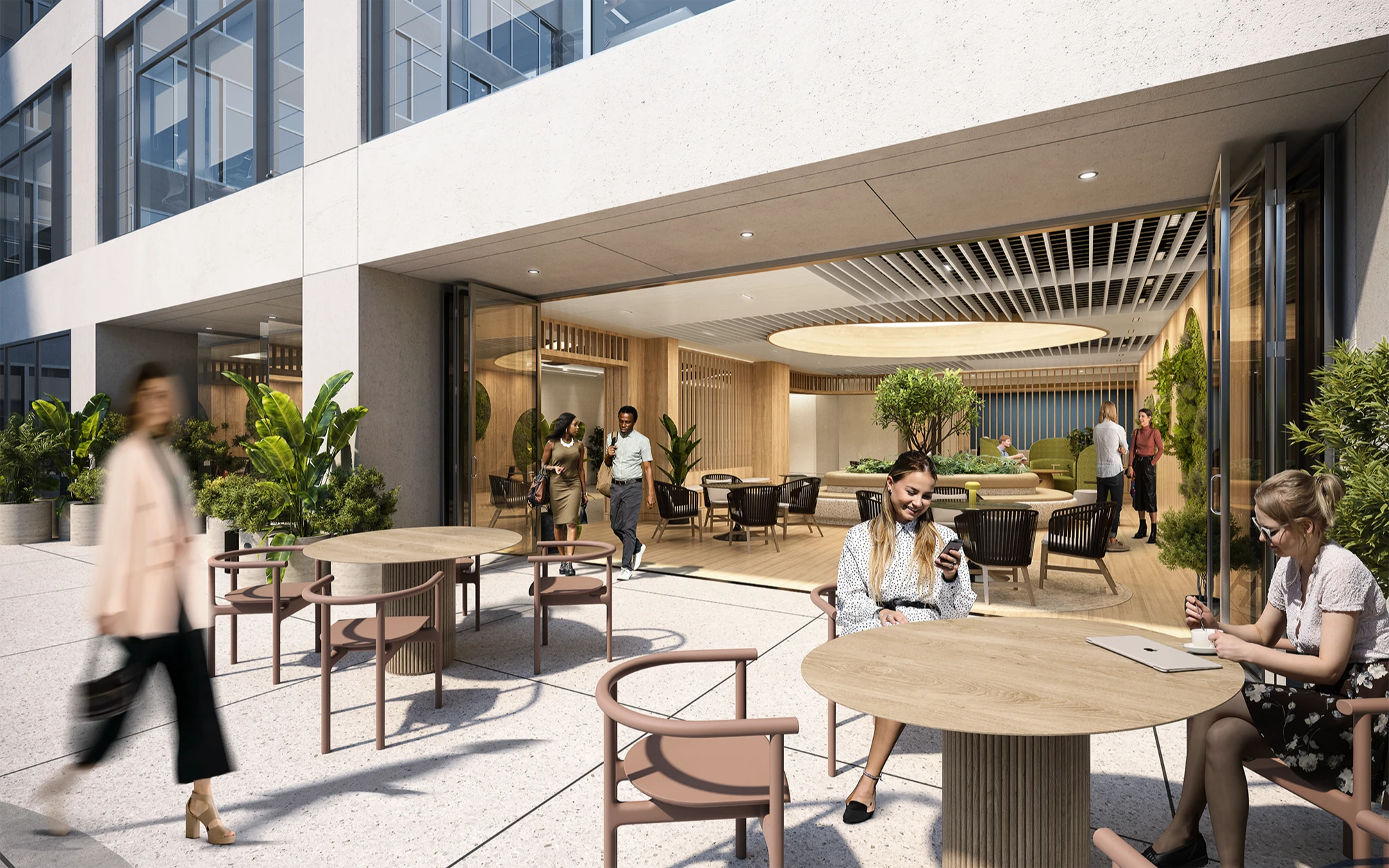 Outdoor office lounge with wooden tables, greenery, and employees enjoying a coffee break